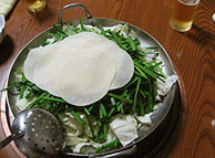 モツ鍋は、大量の二ラに餃子の皮を乗せた状態で運ばれてきます